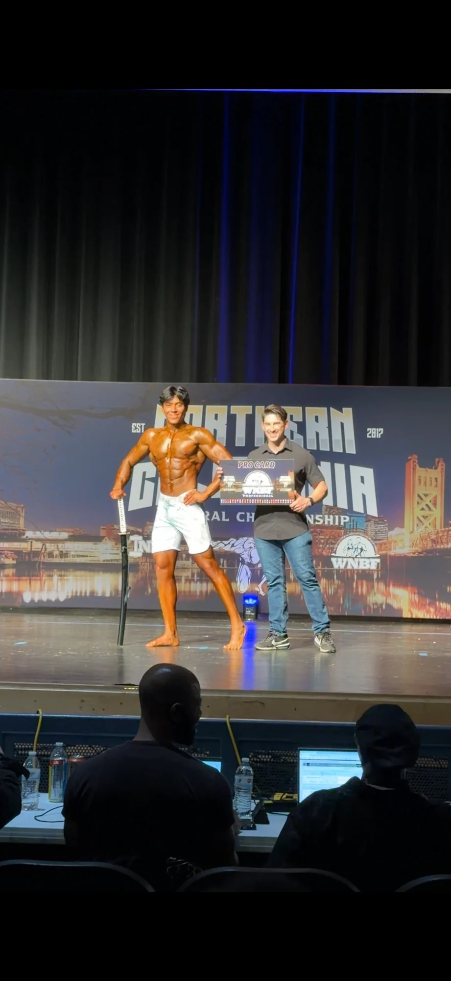 Sebastian receiving his WNBF professional pro card at the Northern California competition